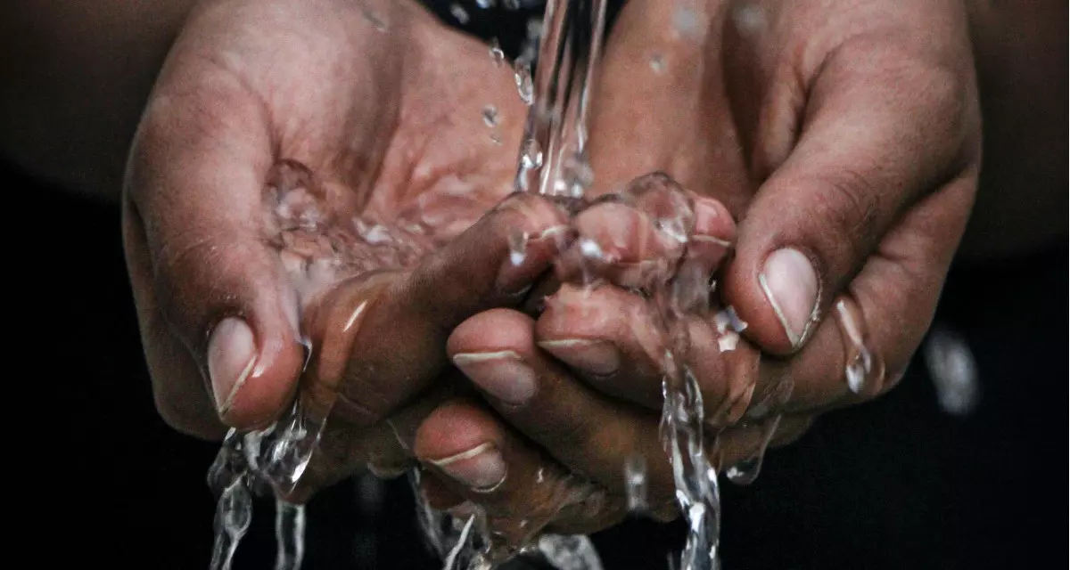 Wasser fließt durch Hände.