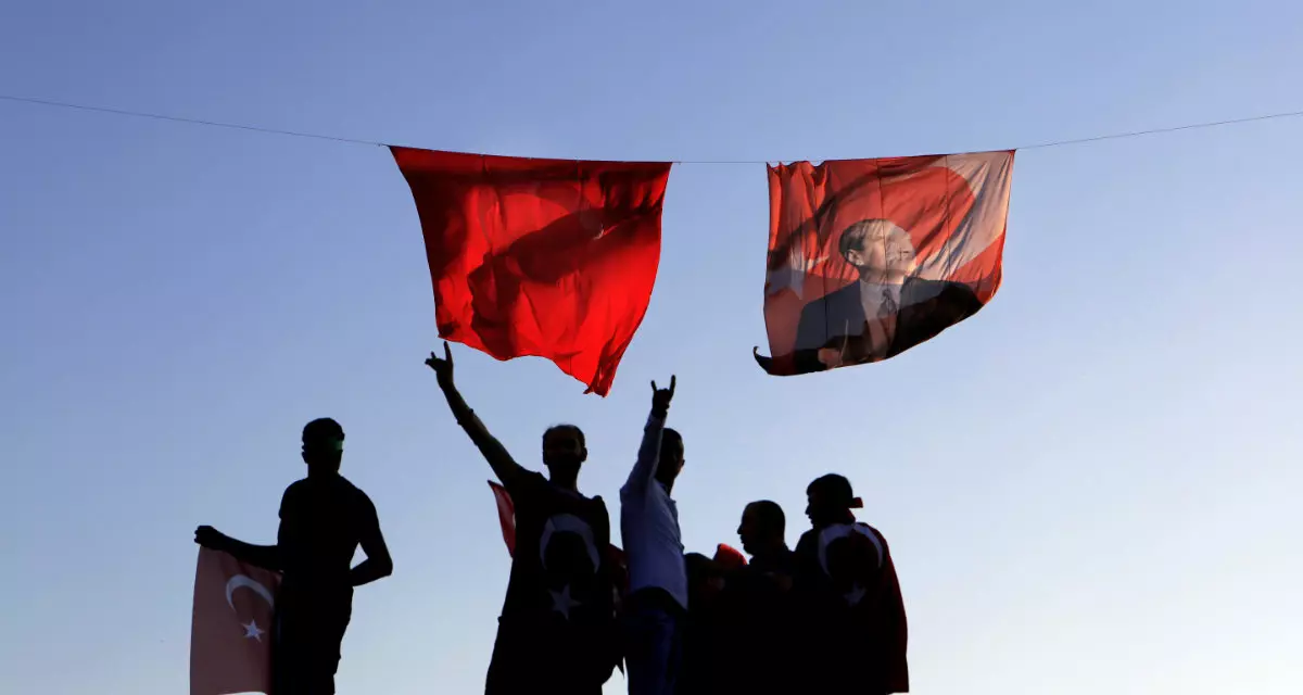 Unterstützer der CHP stehen unter einer Flagge der Türkei, von denen eine das Porträt des Staatsgründers Mustafa Kemal Atatürk trägt. 