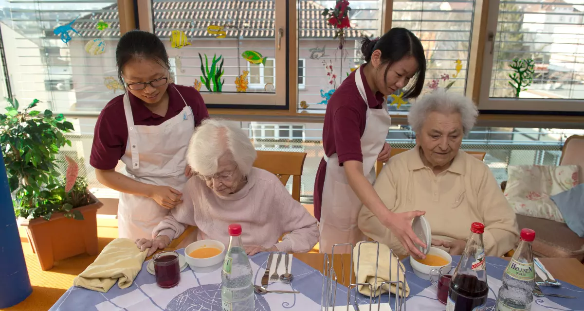 Die beiden Pflegekräfte Linyan Liu (l.) und Qiping Guo (r.) wurden 2015 aus China nach Baden-Württemberg geholt. Sie arbeiten in einer Seniorenwohnanlage in Stuttgart. © picture-alliance/dpa | Marijan Murat