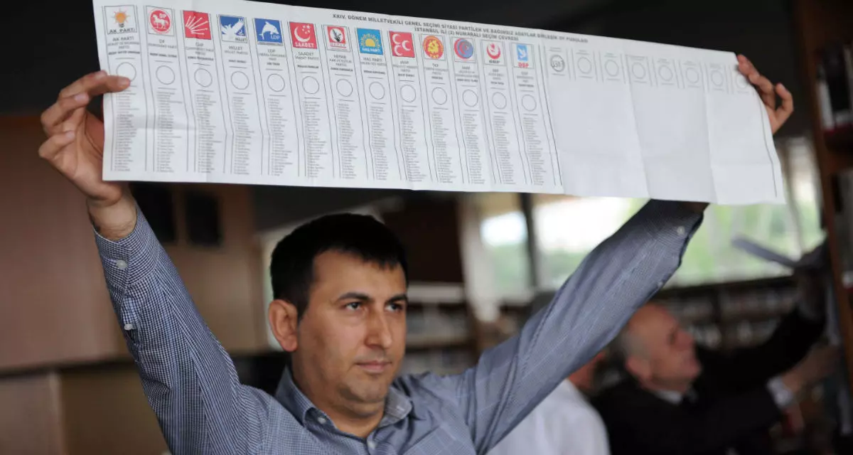 Ein Mann hält einen Stimmzettel in die Höhe, auf dem die türkischen Parteien verzeichnet sind, die 2011 bei den Parlamentswahlen angetreten sind.