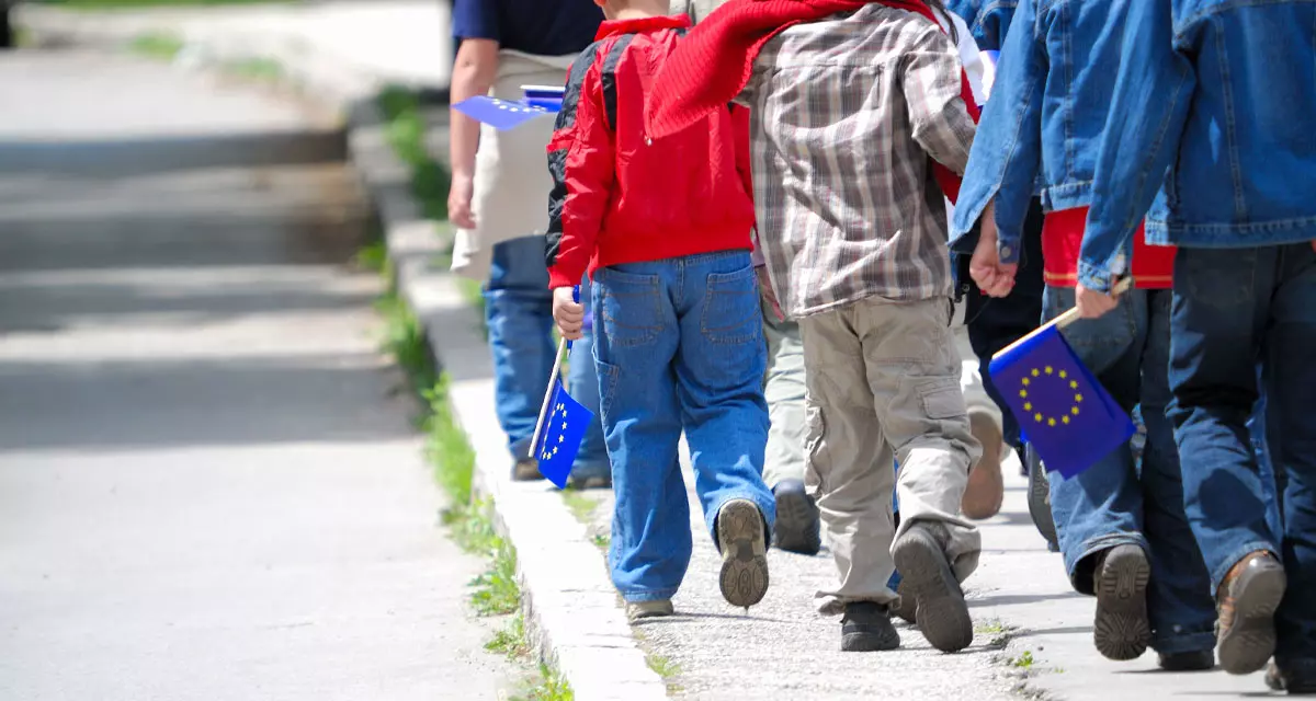 Kinder auf einem Weg mit Europaflaggen in den Händen. Foto: Adobe Stock | .shock