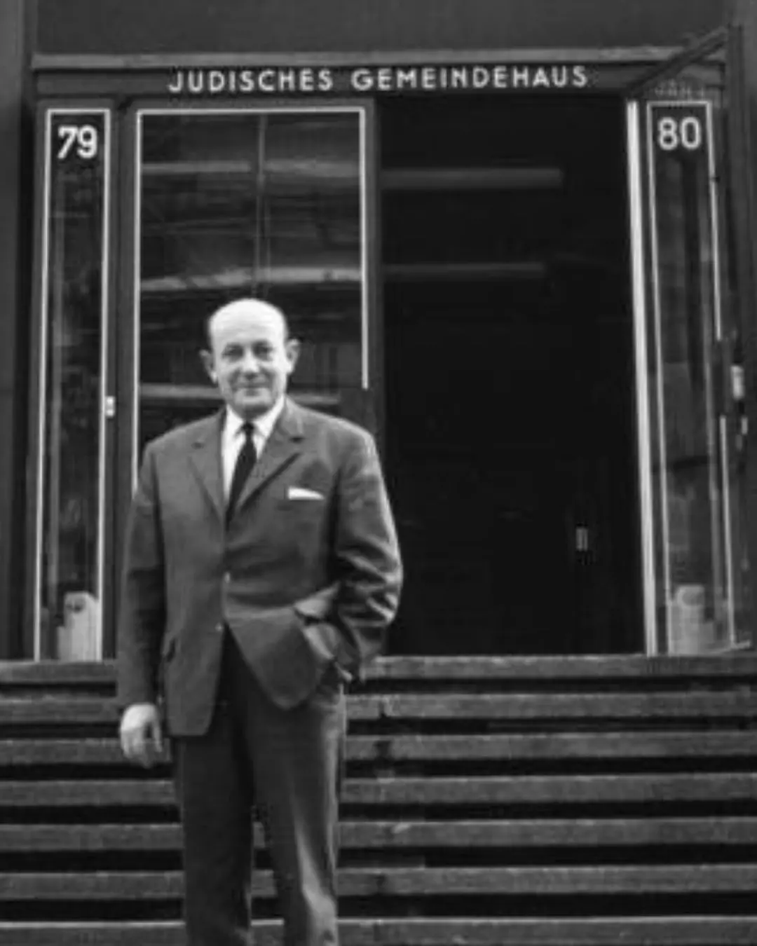 Heinz Galinski, Erster Vorsitzender des Zentralrats der Juden in Deutschland (1954-1063). Bild: Bundesarchiv Nr. B 145 Bild-P094007 In dem Schwarz/Weiß-Bild steht ein Mann mit Glatze und Anzug (Heinz Galinski) steht alleine vor Treppen, die zu einem Eingang führen. Über dem Eingang steht "Jüdisches Gemeindehaus".