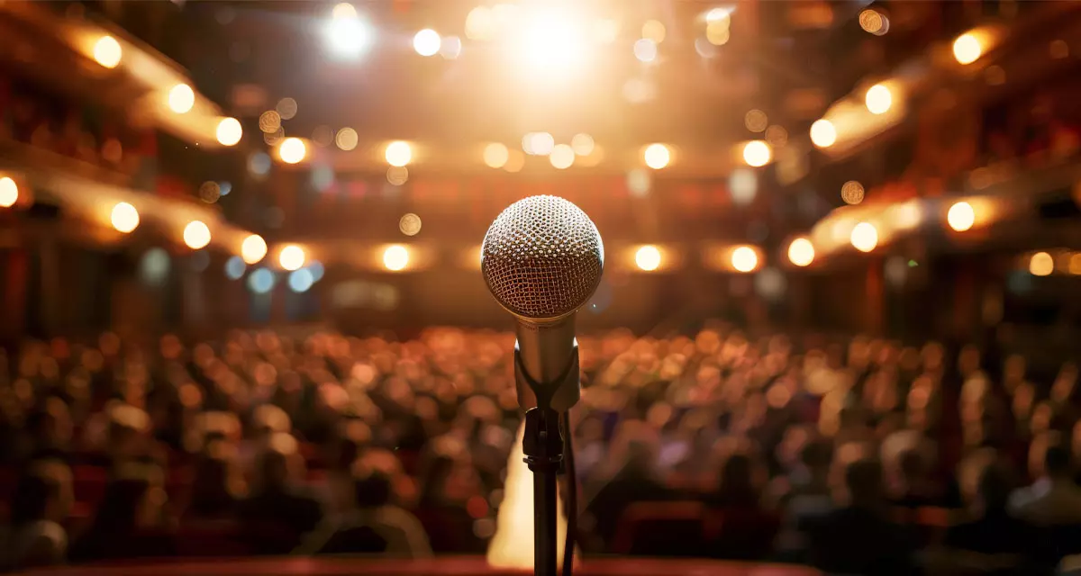 Microphone auf einer Bühne. Foto: Adobe Stock | Cedric, KI-Generiert