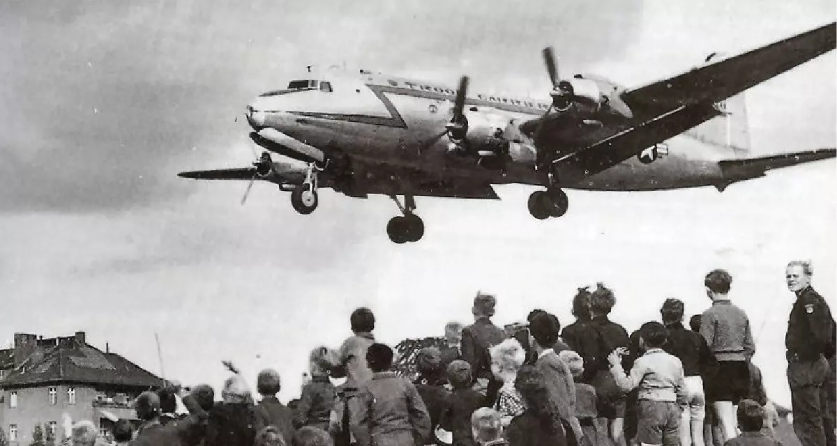 Berliners beobachten die Landung eines C-54-Flieger auf dem Tempelhofer Flughafen in Berlin 1948 .Foto: wikimedia / Henry Ries / USAF, gemeinfrei.