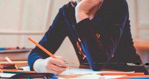 Eine Schülerin hält einen Stift in der Hand.