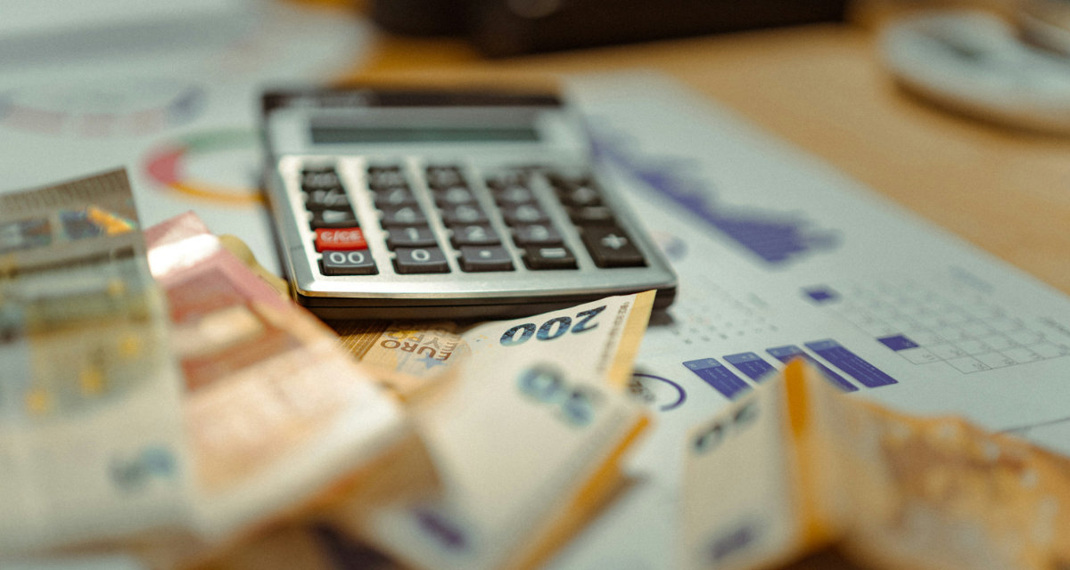 Geldscheine und ein Taschenrechner auf einem Tisch 