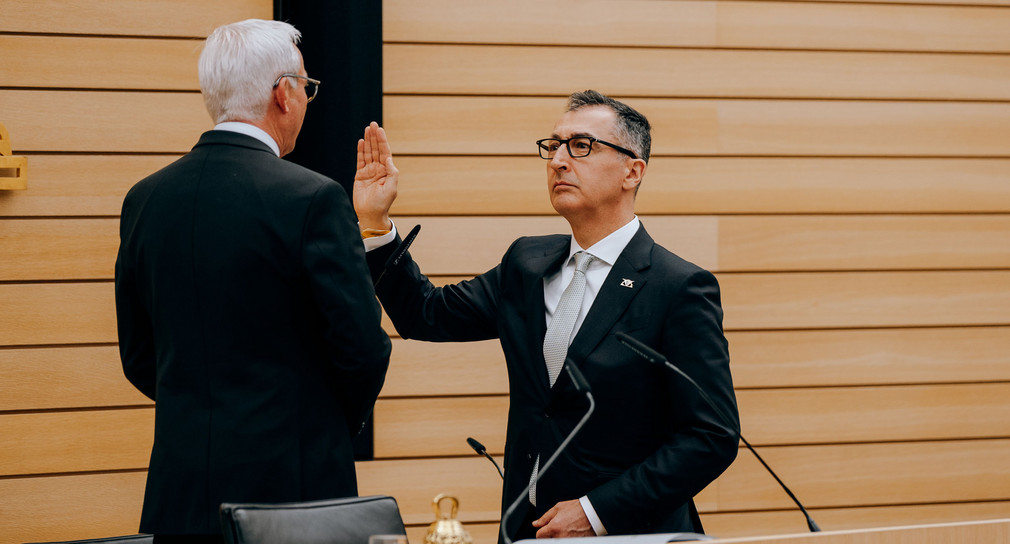 Cem Özdemir hebt die Hand zum Eid, mit dem Rücken zur Kamera Thomas Strobl.