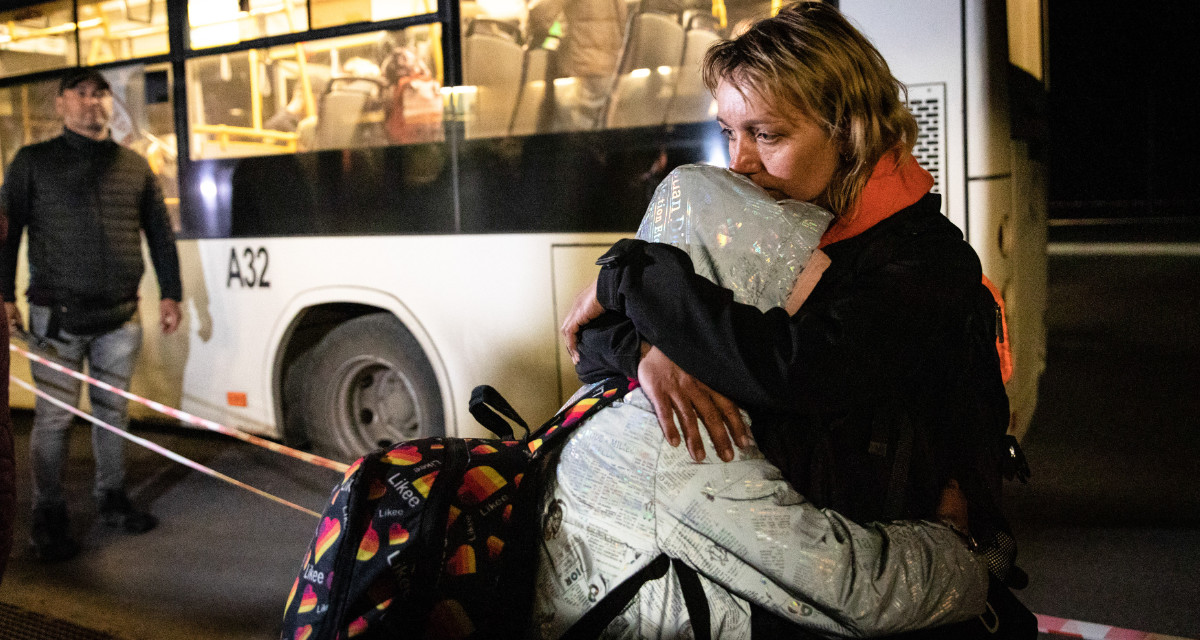 Eine Frau tröstet ihre Tochter bei der Ankunft in Saporischschja. Beide wurden am 8. Mai 2022 aus Mariupol evakuiert. © picture alliance/ZUMAPRESS.com | Alex Chan Tsz Yuk