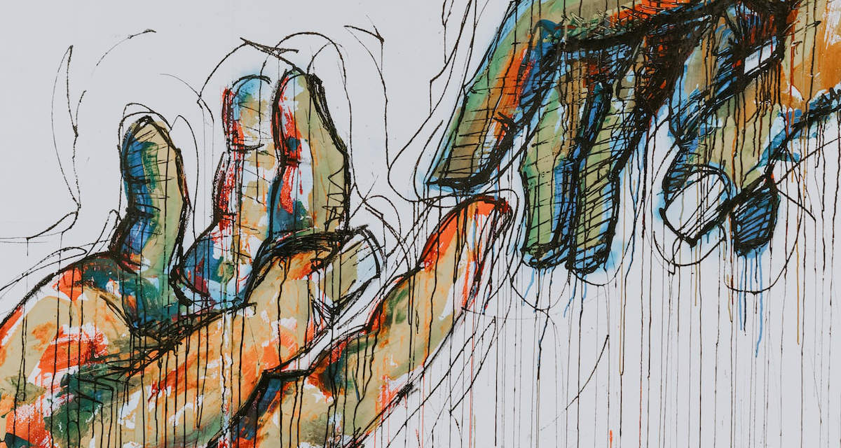 Wandmalerei zweier sich reichender Hände. Foto: unsplash/Claudio Schwarz.