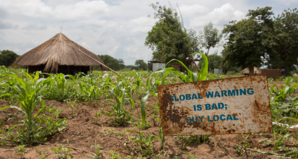 Schild mit der Aufschrift „Global warming is bad, buy local“ als Unterstützung für südsudanesische Flüchtlinge in Uganda. Foto: © UNHCR/Jordi Matas