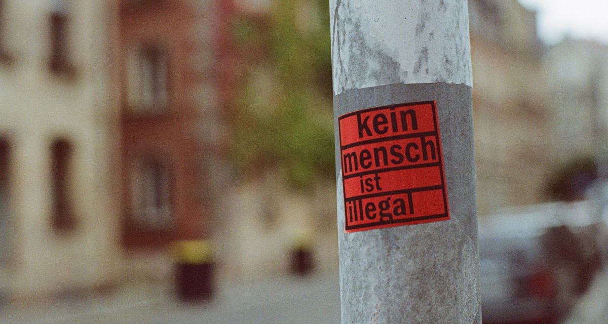 Laternenmast mit Aufkleber „Kein Mensch ist illegal“. Foto: unsplash | Markus Spiske