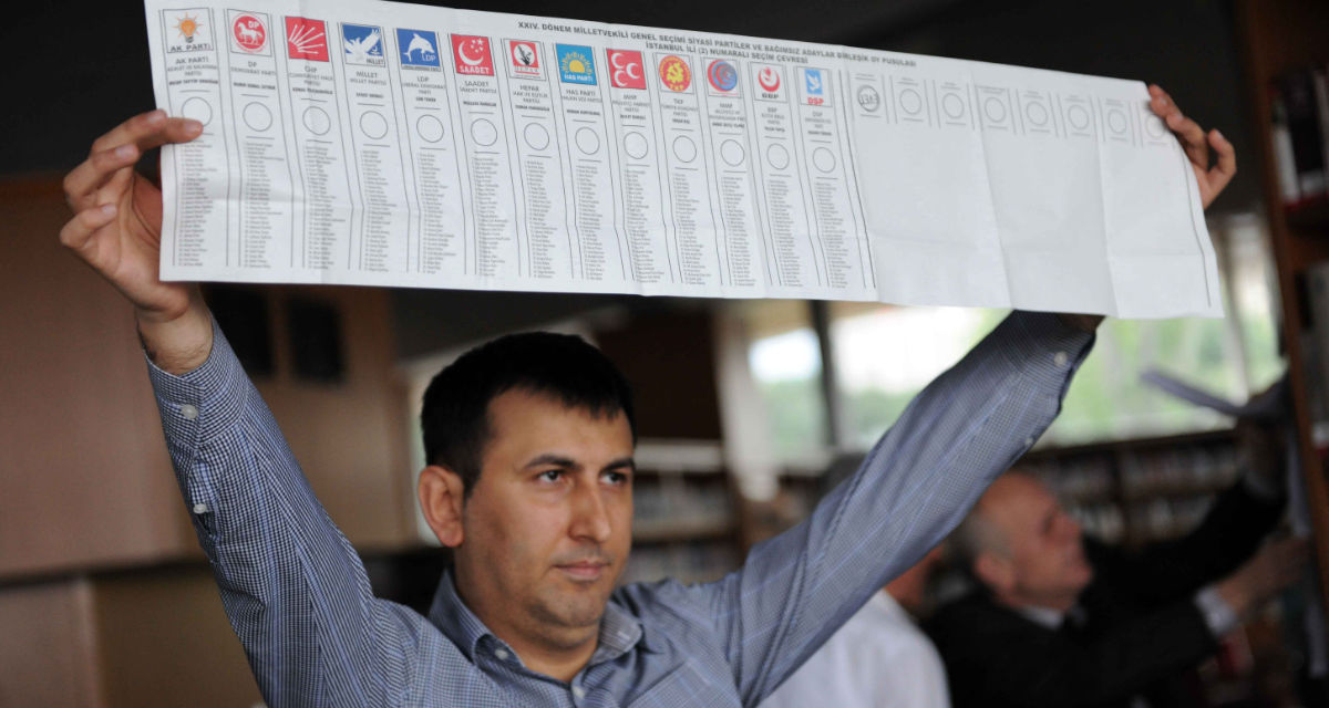 Ein Mann hält einen Stimmzettel in die Höhe, auf dem die türkischen Parteien verzeichnet sind, die 2011 bei den Parlamentswahlen angetreten sind.