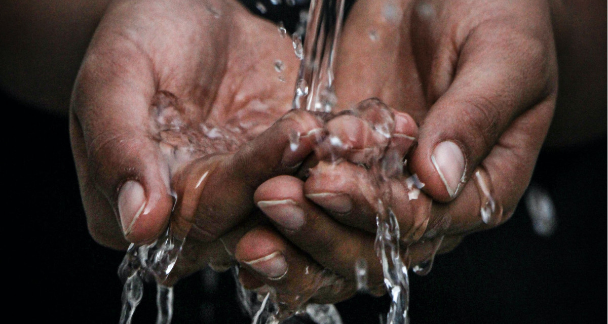 Wasser fließt durch Hände.