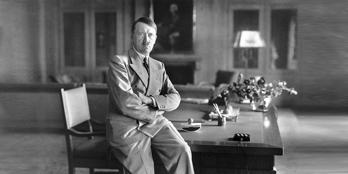 Adolf Hitler in Zivilkleidung auf Schreibtisch sitzend (Porträt), Obersalzberg, Berghof. Foto: Bundesarchiv, Bild 146-1990-048-29A / Heinrich Hoffmann / CC BY-SA 3.0 DE Adolf Hitler in Zivilkleidung auf Schreibtisch sitzend (Porträt), Obersalzberg, Berghof. Foto: Bundesarchiv, Bild 146-1990-048-29A / Heinrich Hoffmann / CC BY-SA 3.0 DE