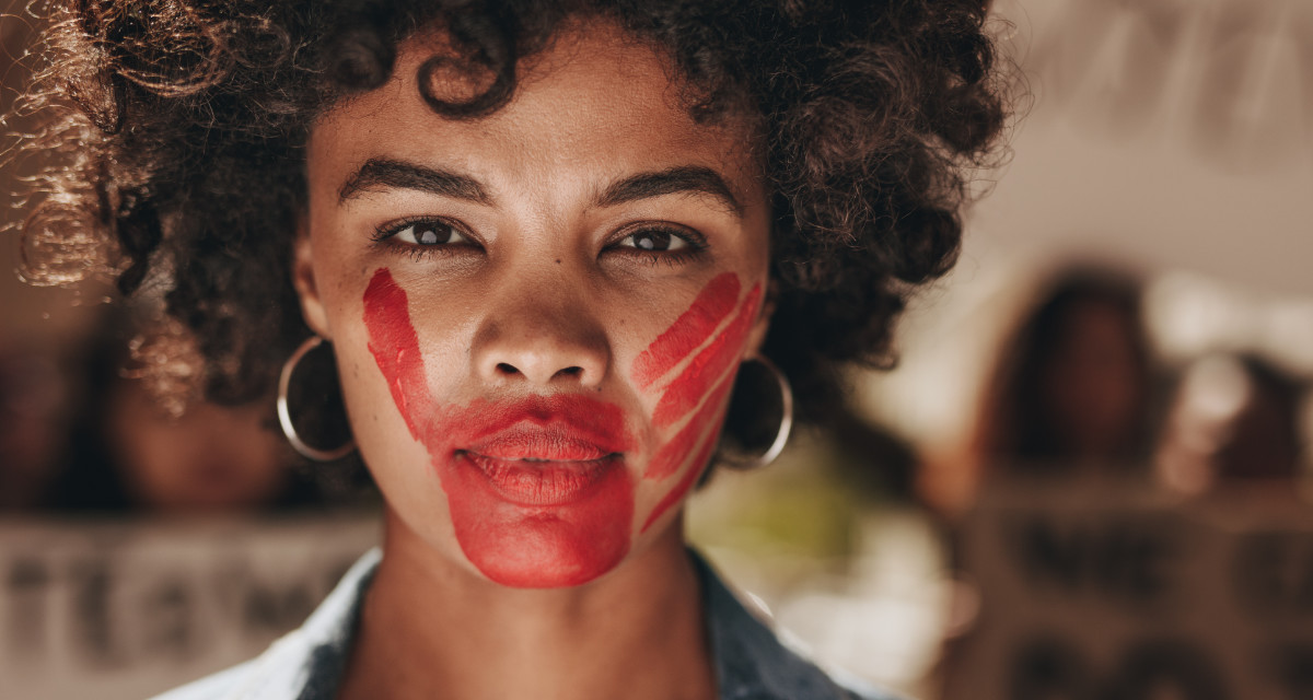 Frau, die mit einer roten Hand im Gesicht gegen Gewalt an Frauen protestiert. Foto: Adobe Stock | Jacob Lund 