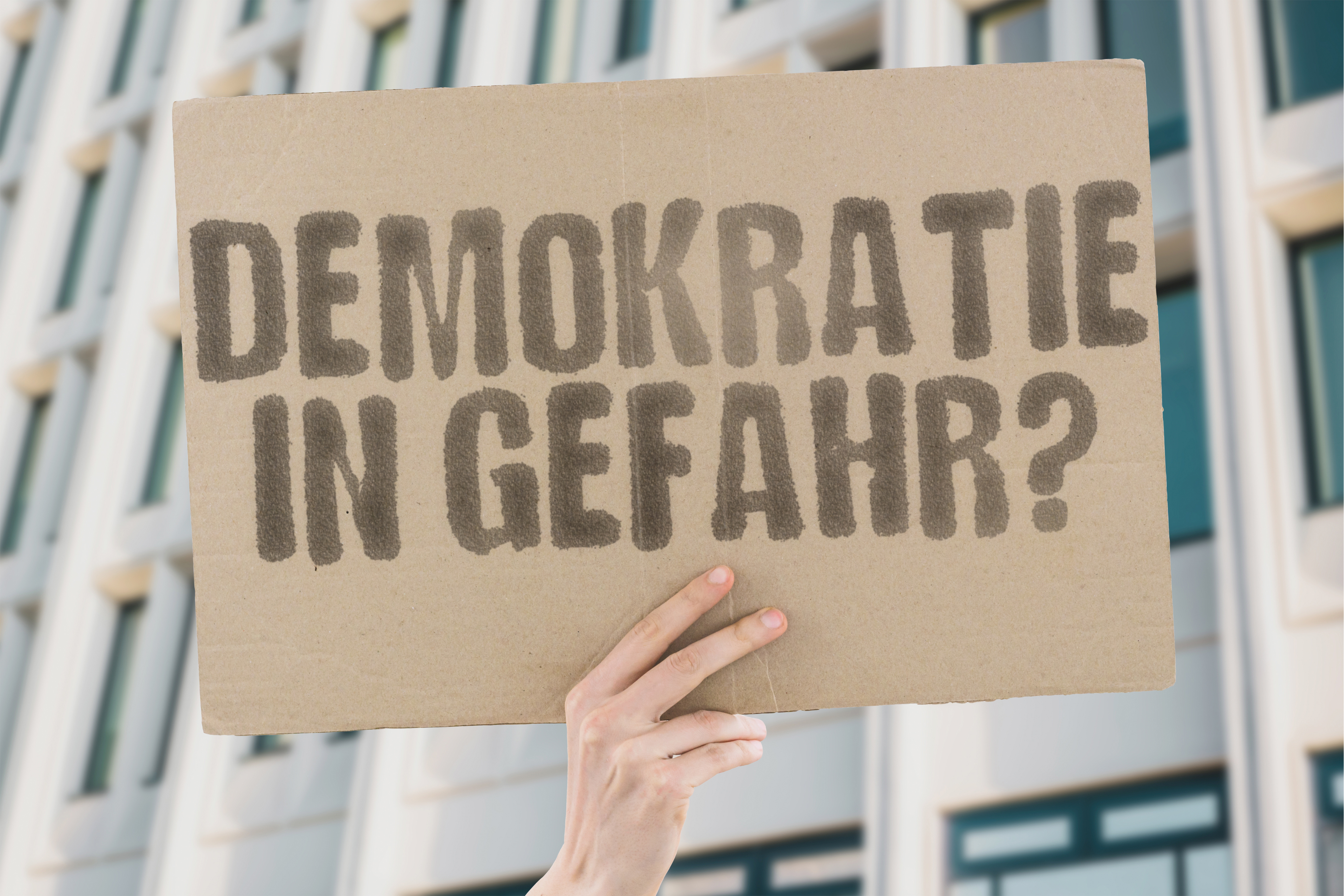 Pappschild Demokratie in Gefahr / Quelle: AdobeStock | 1147675523 Pappschild Demokratie in Gefahr