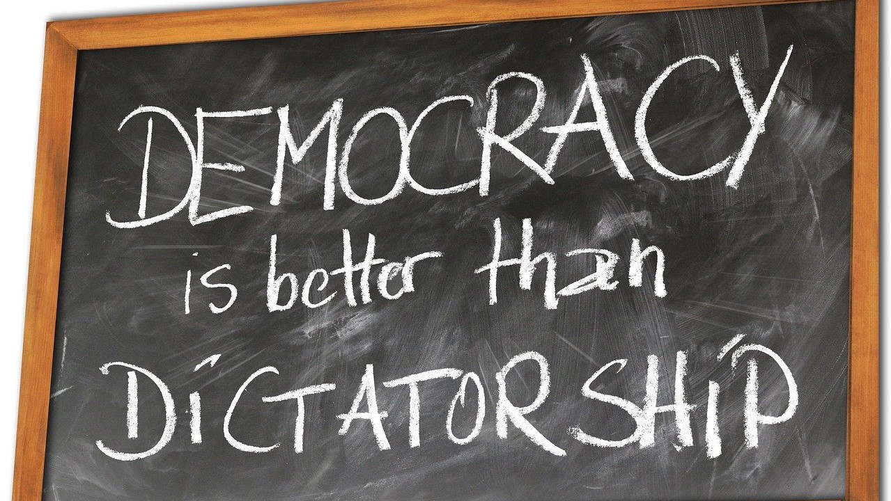Bild einer Tafel auf der auf englisch steht, dass Demokratie besser als Diktatur ist.